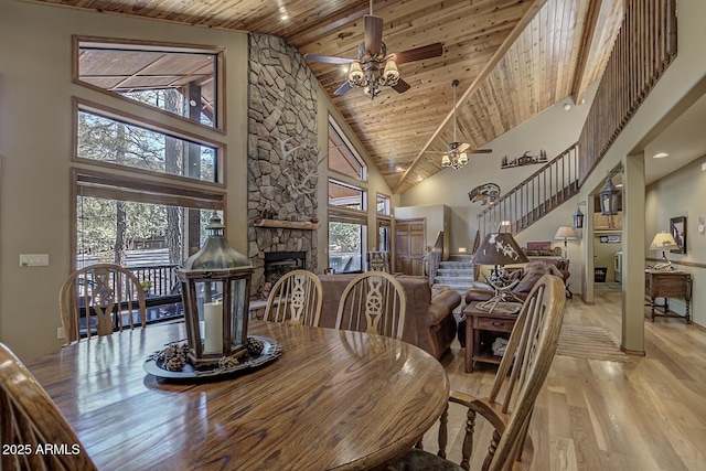 dining space featuring stairway, plenty of natural light, wood ceiling, and a fireplace