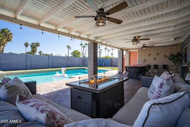 view of pool with a patio and an outdoor living space with a fire pit