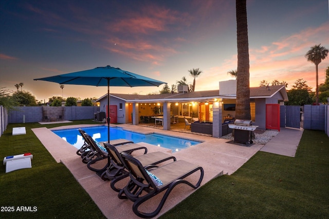 pool at dusk with grilling area, a lawn, an outdoor hangout area, and a patio