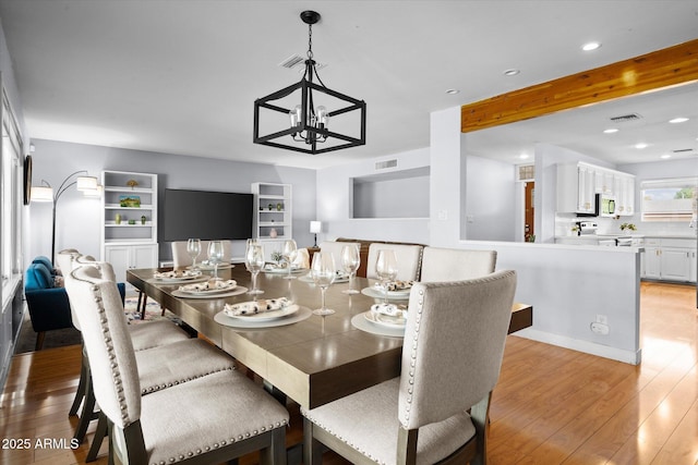 dining area featuring light hardwood / wood-style floors and a notable chandelier