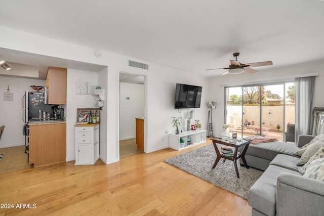 living room featuring light hardwood / wood-style floors and ceiling fan