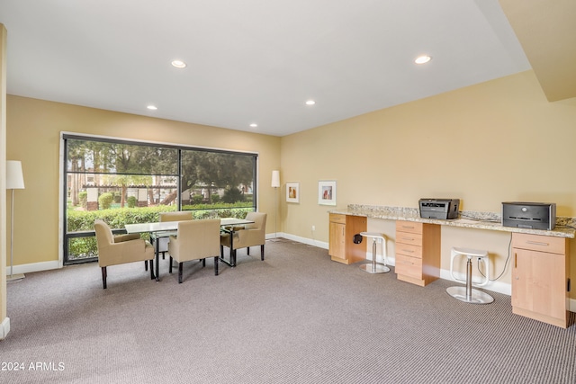 dining area with plenty of natural light, built in desk, and light colored carpet