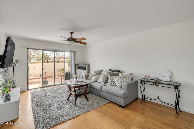 living room with ceiling fan and light hardwood / wood-style flooring