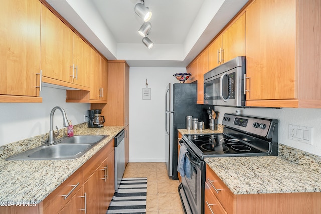 kitchen featuring stainless steel appliances, light tile floors, rail lighting, and sink