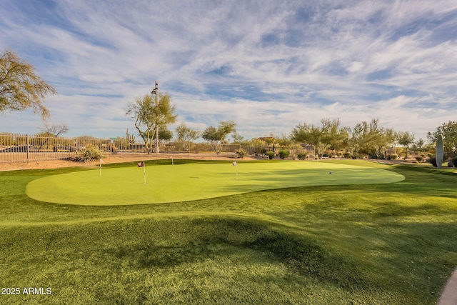 view of home's community featuring view of golf course and fence