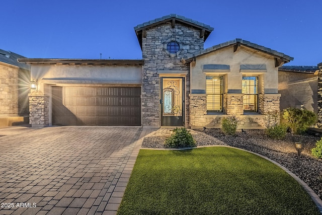 view of front of house featuring stone siding, decorative driveway, an attached garage, and stucco siding