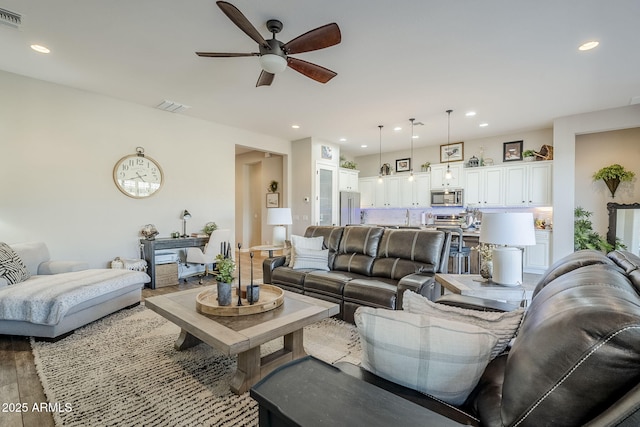 living room with wood finished floors, visible vents, and recessed lighting