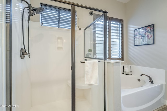 bathroom featuring a stall shower, a garden tub, and plenty of natural light