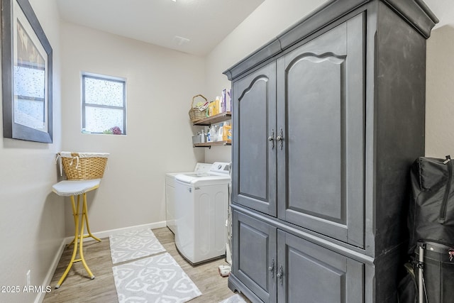 laundry area with washing machine and dryer, laundry area, baseboards, and light wood finished floors