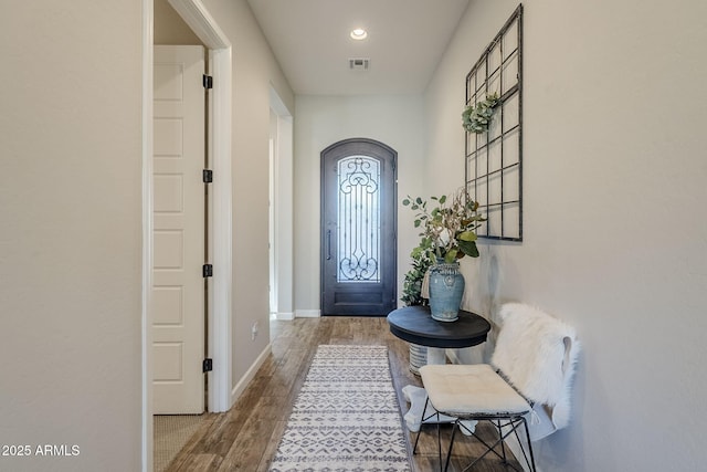 doorway to outside with recessed lighting, visible vents, baseboards, and wood finished floors