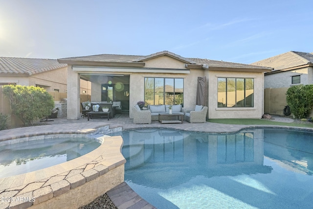 back of property featuring stucco siding, a pool with connected hot tub, an outdoor hangout area, a patio area, and fence