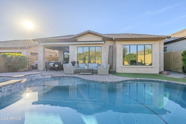 rear view of house with an outdoor pool, fence, a patio area, outdoor lounge area, and stucco siding