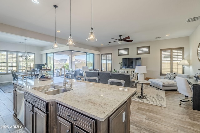 kitchen with visible vents, open floor plan, hanging light fixtures, a sink, and recessed lighting