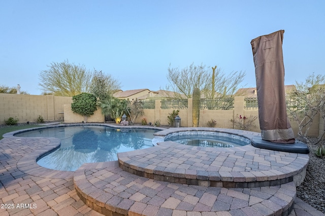 view of pool featuring a fenced in pool, a patio area, a fenced backyard, and an in ground hot tub