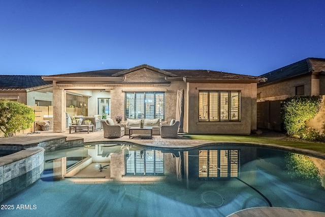 back of house featuring outdoor lounge area, fence, a pool with connected hot tub, stucco siding, and a patio area