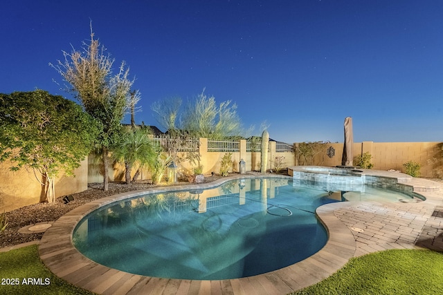 view of swimming pool featuring a patio area, a pool with connected hot tub, and a fenced backyard