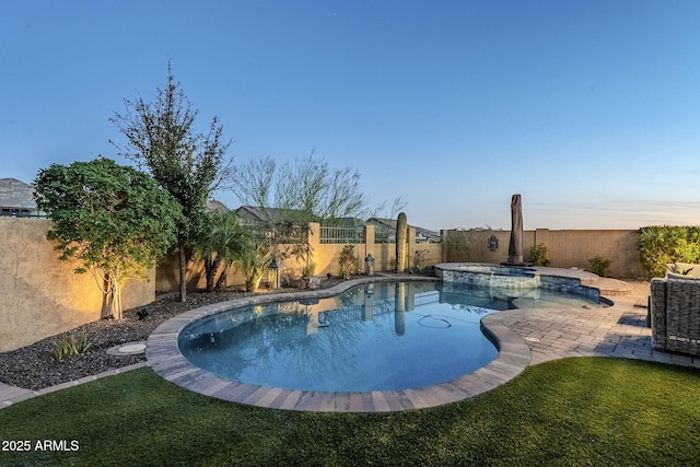 view of pool with a yard, a patio area, a fenced backyard, and a pool with connected hot tub