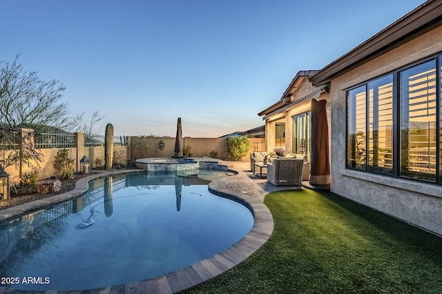 view of pool with a yard, a pool with connected hot tub, a fenced backyard, and a patio