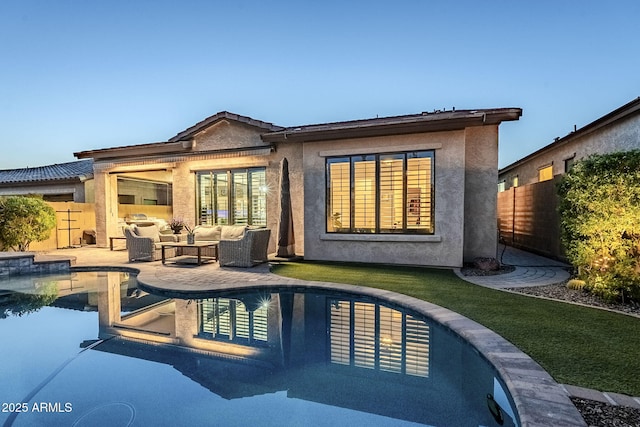 rear view of house with stucco siding, outdoor lounge area, a patio area, fence, and an outdoor pool