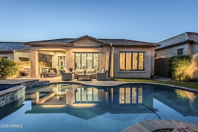 rear view of property featuring stucco siding, a patio area, an outdoor living space, and a fenced in pool