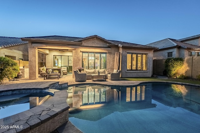 rear view of house featuring fence, a patio area, a pool with connected hot tub, an outdoor living space, and stucco siding