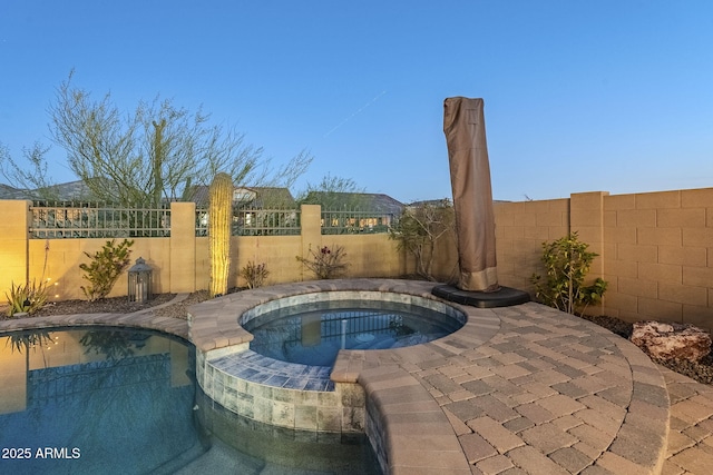 view of swimming pool with an in ground hot tub and a fenced backyard