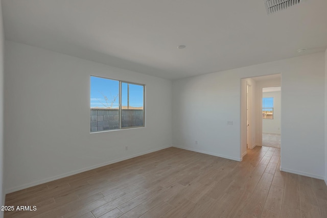 empty room featuring light wood-type flooring and a healthy amount of sunlight