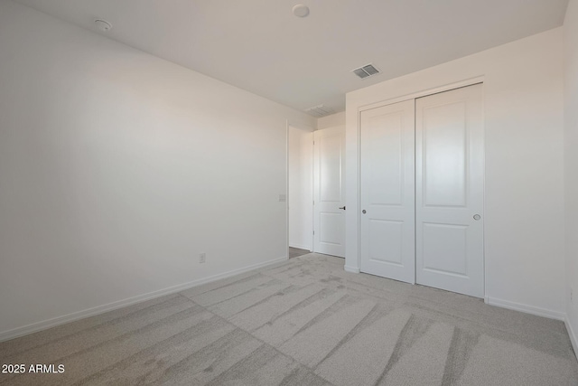 unfurnished bedroom with a closet and light carpet