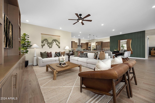 living room with ceiling fan and light wood-type flooring