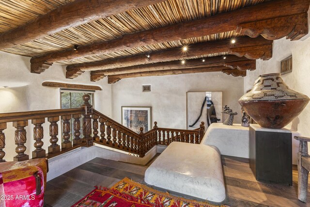 living area with dark wood-type flooring, beamed ceiling, wooden ceiling, and stairway