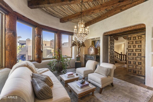 living area with wooden ceiling, a notable chandelier, wood finished floors, stairs, and beamed ceiling