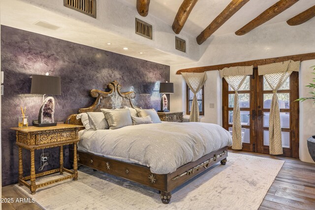 bedroom featuring visible vents, french doors, beam ceiling, and wood finished floors