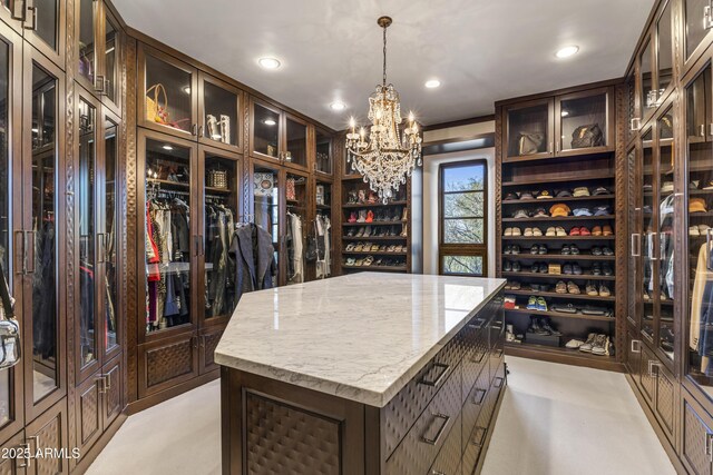 spacious closet featuring an inviting chandelier