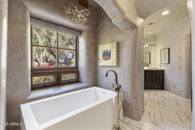 bathroom featuring a freestanding bath and vanity