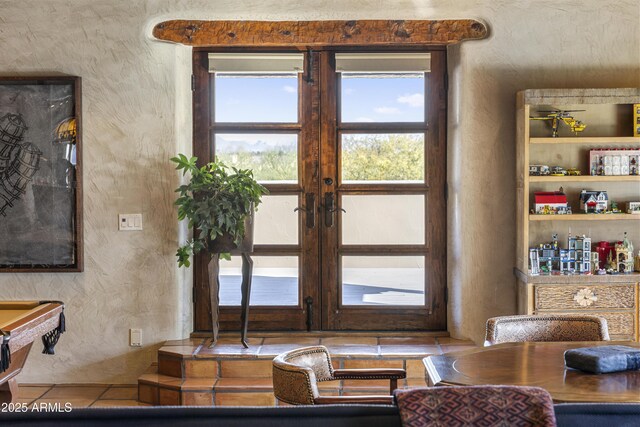 interior space featuring french doors and a textured wall