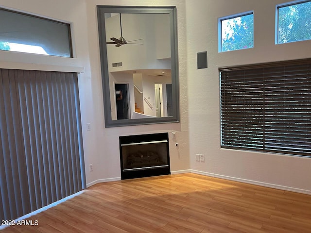 9070 E Gary Rd Unit 152, Scottsdale, AZ 85260 - unfurnished living room with a ceiling fan, a fireplace, and wood finished floors