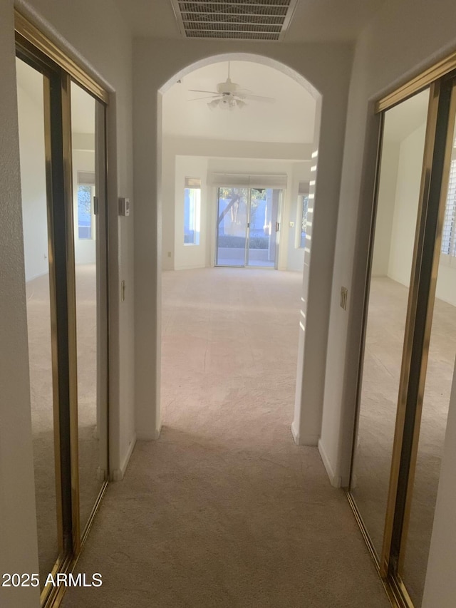 hallway featuring light colored carpet