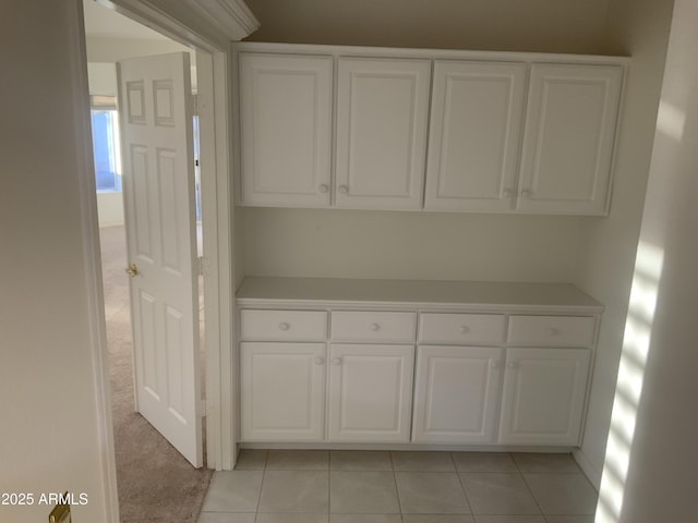 interior space with light carpet and white cabinets