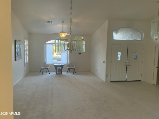 foyer entrance with a towering ceiling and light colored carpet