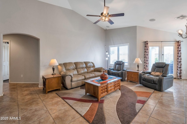 living room with visible vents, high vaulted ceiling, ceiling fan with notable chandelier, arched walkways, and light tile patterned floors