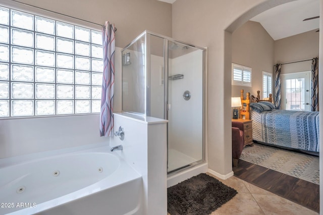 full bath with connected bathroom, a whirlpool tub, a shower stall, and tile patterned flooring