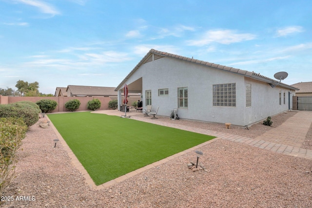 rear view of property with a patio area, a fenced backyard, and stucco siding