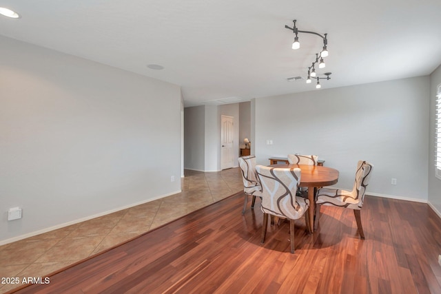 dining area with visible vents, baseboards, and wood finished floors