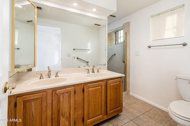 bathroom featuring vanity, a shower, tile patterned floors, and toilet