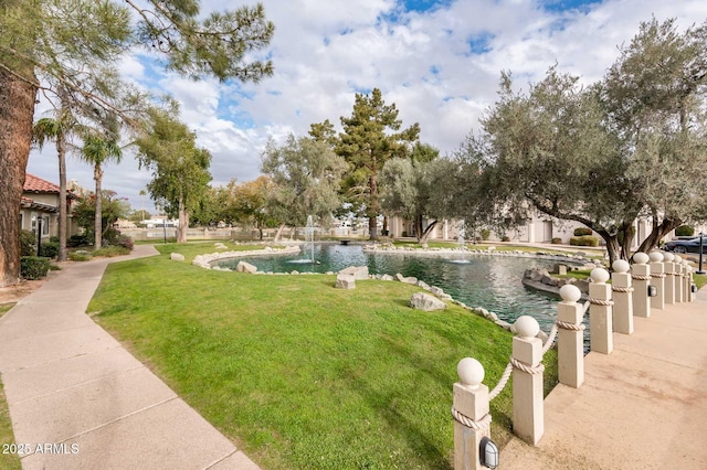 view of property's community with a yard and a water view