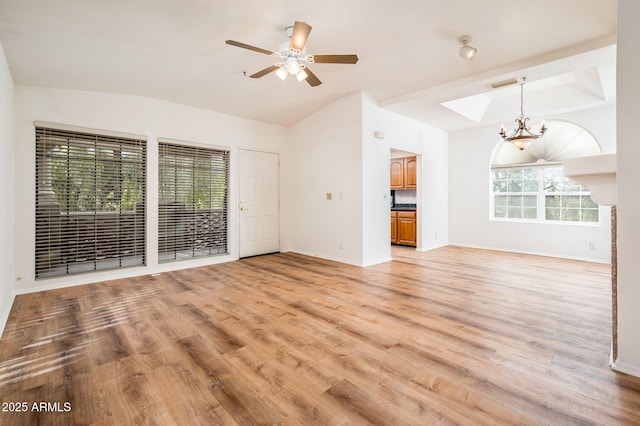 unfurnished living room featuring lofted ceiling, ceiling fan with notable chandelier, and light hardwood / wood-style floors