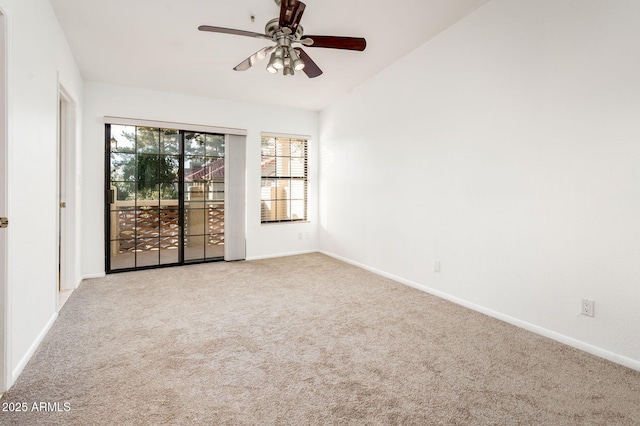 empty room featuring lofted ceiling, carpet floors, and ceiling fan