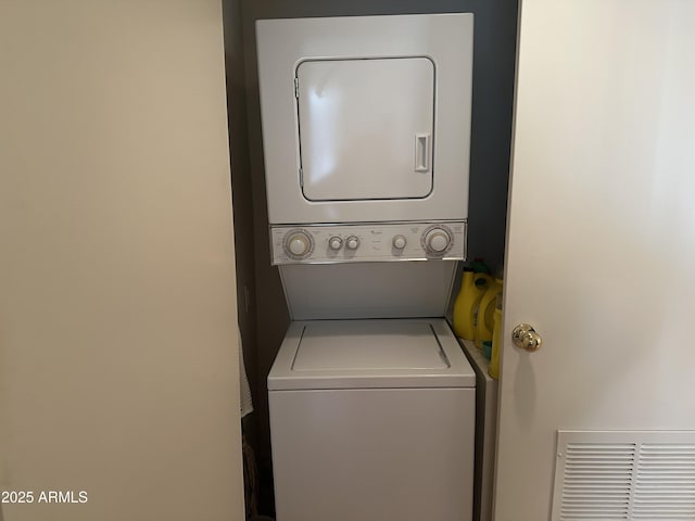 clothes washing area featuring stacked washer and clothes dryer