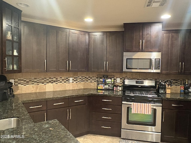 5350 E Deer Valley Dr Unit 3267, Phoenix, AZ 85054 - kitchen with stainless steel appliances, decorative backsplash, dark brown cabinets, dark stone counters, and recessed lighting