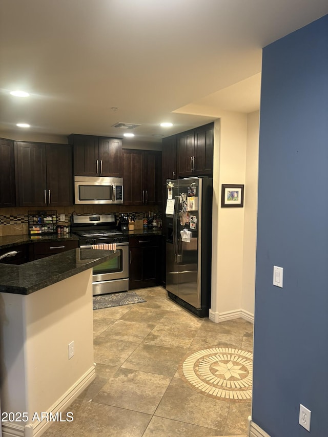 5350 E Deer Valley Dr Unit 3267, Phoenix, AZ 85054 - kitchen featuring appliances with stainless steel finishes, baseboards, dark stone counters, decorative backsplash, and dark brown cabinetry